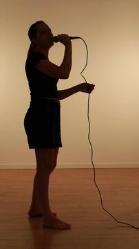 silhueta de mulher com microfone se expressando 