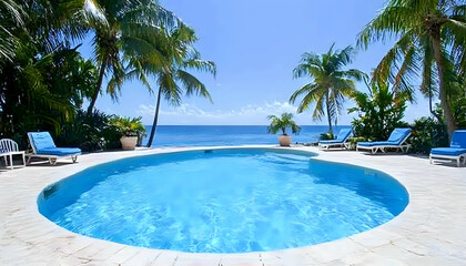 Idyllic tropical poolside view; turquoise water, palm trees, ocean backdrop