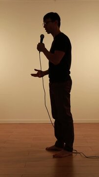 silhueta de homem com microfone falando em palestra 