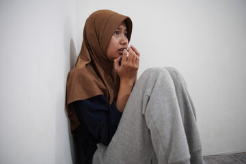 Depressed Asian muslim woman looks terrified, worried of something bad