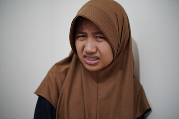 Asian muslim woman looking with disgusted expression, gestures of rejection and feeling...