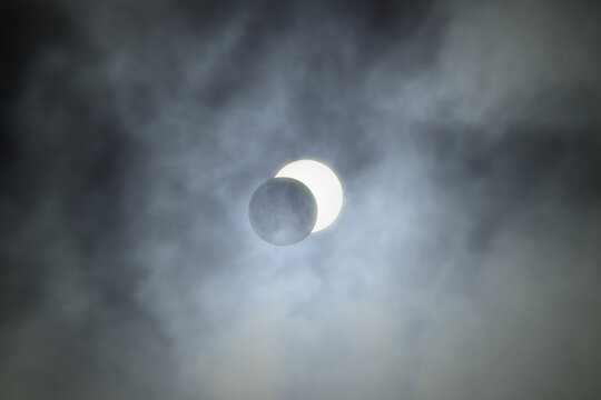 partial solar eclipse between the clouds