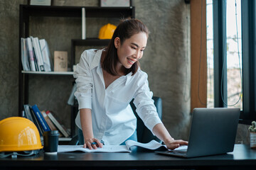 Female architect in a modern office reviewing blueprints, showcasing professionalism and creativity in an industrial setting.