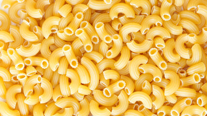 close-up view of dry elbow macaroni pasta, showcasing its curved tubular shape and golden-yellow...