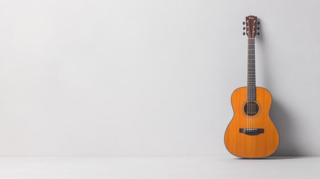 minimalistic arrangement of elegant acoustic guitar leaning against blank white wall with ample copy space