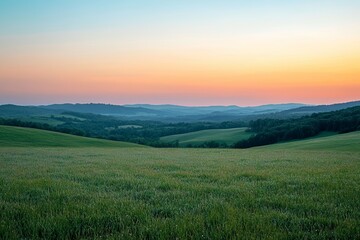 Obraz premium A scenic landscape features rolling green hills and a beautiful sunset