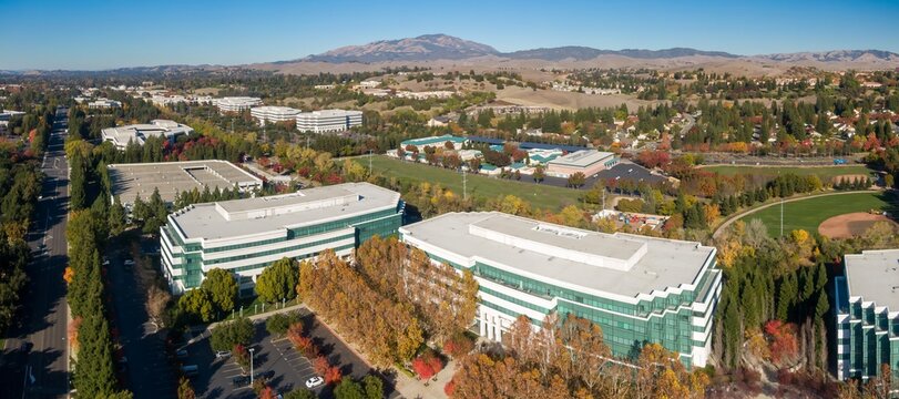 Aerial view of office buildings in San Ramon, California, USA, during autumn. The photo showcases the architecture and landscape of a suburban business park.