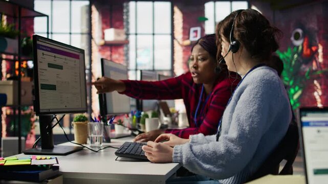 Account manager supervising work done by employee talking with customers to identify sales opportunities. Supervisor overseeing agent in office bonding with client to generate leads, camera B