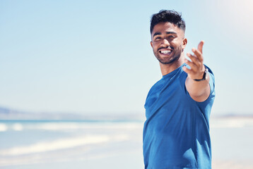 Fototapeta premium Man, portrait and welcome on beach for fitness or run, join workout and physical cardio by ocean for health. Male person, happy and hand gesture for invitation to come exercise, motivation and space.