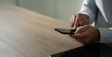 man holding en hands and using digital tablet Mobile Phone telephone with blank copy space scree