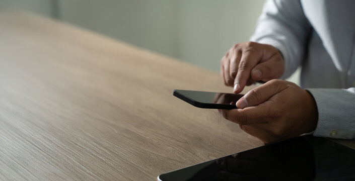 man holding en hands and using digital tablet Mobile Phone telephone with blank copy space scree