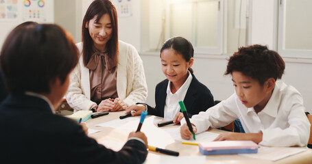 Japanese, teacher and students for education in classroom, creative learning and art assessment of growth. Children, educator and teaching of studying with support, helping and lesson advice in Japan © peopleimages.com