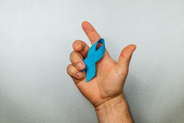 Supporting cancer awareness with a blue ribbon symbolizing hope and courage