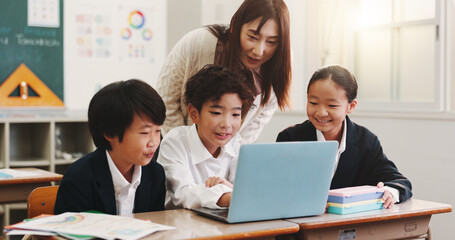 Kids, laptop and teacher in classroom for education, reading and happy with project at academy. People, children and computer with studying, scholarship and e learning with guide at school in Japan