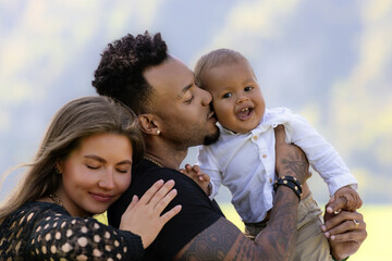 Mixed race family outdoor portrait. Parents and child family portrait in park. Happy African...
