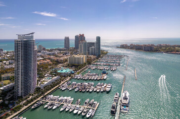 Obraz premium Luxury yacht cruising on Miamis coastline. Aerial view of yachts docked in Miami marina. Miami skyline yachts. Miami Beach with yacht in bay. Summer vacation in Miami. Yachts in South Pointe Marina.