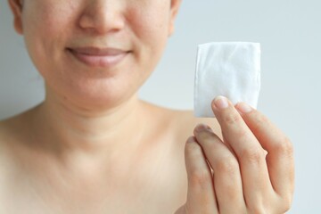 Woman holding cotton pad in hand, health concept