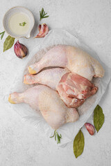 various parts of raw chicken on a light background