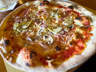 Delicious italian pizza with mushrooms, artichokes, and ham on crisp crust