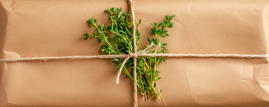 package wrapped in recycled paper with jute twine and herbs