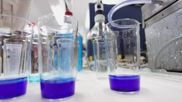 Science lab low angle: Measured buffer solution added to purple liquid