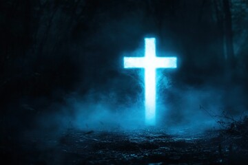 Fototapeta premium Radiant blue Christian cross glowing in mystical forest under fog and shadows in the deep night