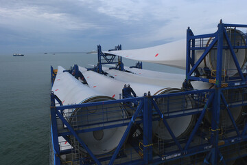 Long blades with root ends of wind turbine loaded and lashed on the heavy load carrier vessel.
