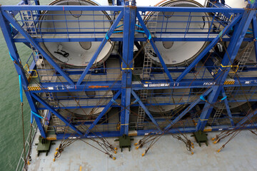 Root ends of long blades of off shore wind turbine loaded and lashed on the heavy load carrier vessel sailing in North Sea.
