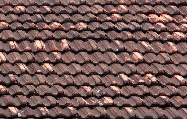 A brown roof with red tiles