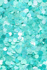 Shimmering turquoise sequins create vibrant, festive background