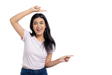 Happy young Asian woman pointing at copy space and smiling, celebrating success or achievement, isolated on transparent background