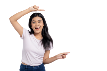 Happy young Asian woman pointing at copy space and smiling, celebrating success or achievement, isolated on transparent background