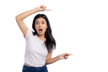 Surprised young Asian woman pointing at copy space and looking shocked, celebrating or announcing something, isolated on transparent background