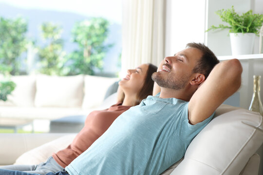 Happy couple sitting and relaxing in a couch at home