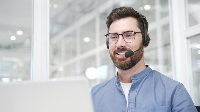 Corporate operator in headset working in customer support service on helpline telesale talking using laptop in business office. Agent of call center advises the client by answering questions. Close up