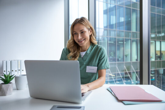 Woman doctor in hospital working with computer preparing medical documents - Powered by Adobe