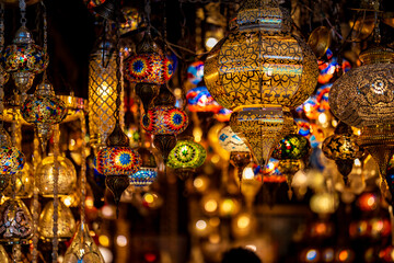 Traditional Turkish mosaic and metal lanterns hanging in a vibrant market stall, creating a warm, colorful, and decorative atmosphere with intricate handcrafted details.