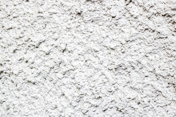 A detailed closeup view of a white wall featuring a rough texture