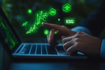 A businessman using a laptop, with his finger pointing to a virtual graph of green stock growth for an ESG (Environmental, Social, and Governance) concept