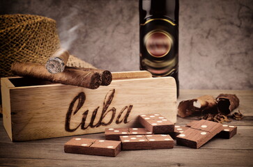 Cigar with smoke, tobacco leaf.  Handmade in Cuba. Still life with domino play.