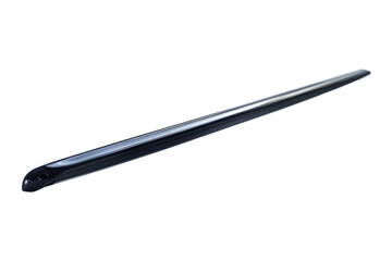 A sleek black stick resting on a smooth, white surface under soft natural light during midday