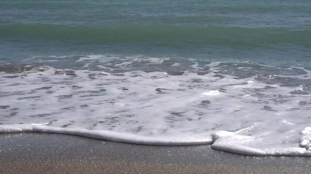 Zoom in on the gentle waves at sea. Summer theme.