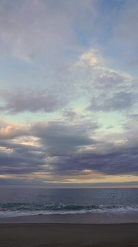 Time-lapse at sea at sunset. You can see the sand, waves, and clouds. The passage of time.