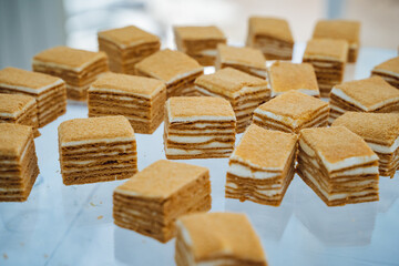 A delightful assortment of various pieces of cake are neatly stacked on top of each other, creating...