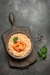 Risotto with shrimps in a bowl on a dark rustic background