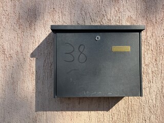 Black Mailbox Mounted on Wall With Number 38