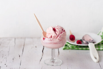 Homemade Raspberry Ice Cream in a Glass on a White Wooden Table.