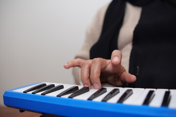 Anonymous woman playing pianica, melodica blow organ