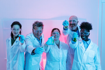 Scientists showing test tubes with colorful chemical liquids in laboratory