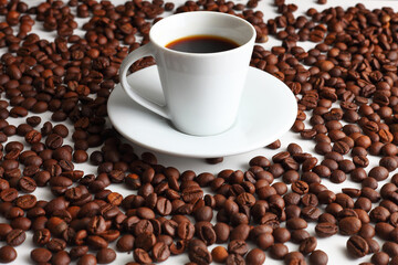 Steaming Coffee Next to Roasted Beans on a Pure White Surface